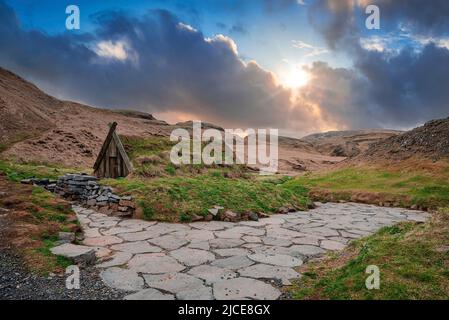 Schönes Rasenhaus und geothermische heiße Quelle in Hrunalaug gegen bewölkten Himmel Stockfoto