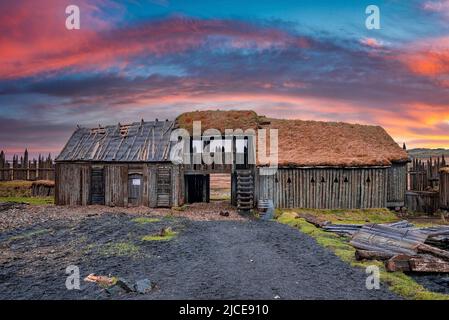 Traditionelles Holzhaus im Wikingerdorf vor dramatischem Himmel während des Sonnenuntergangs Stockfoto