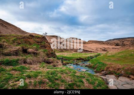 Turf House und geothermische heiße Quelle in Hrunalaug Blick Berg gegen Himmel Stockfoto