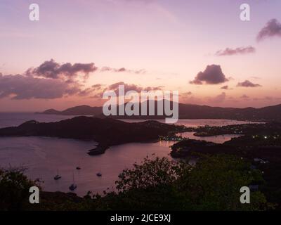 Blick vom Shirley Heights Lookout in Antigua auf den englischen Hafen bei Sonnenuntergang und mit Falmouth Harbour im fernen Hintergrund Stockfoto