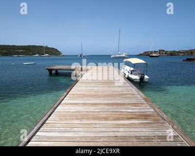 Blick auf einen hölzernen Steg, der sich bis ins karibische Meer in Antigua erstreckt Stockfoto