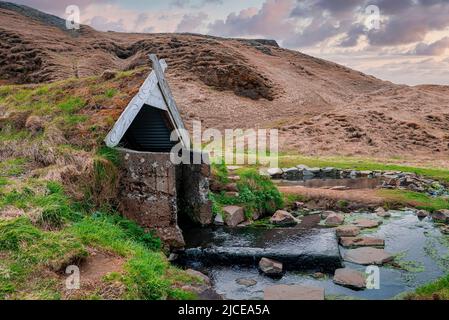 Geothermische heiße Quelle und Turf Haus in Hrunalaug am Berg gegen den Himmel Stockfoto