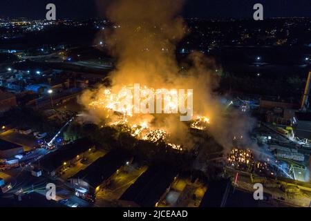 Nechells, Birmingham, England, 12. Juni 2022. Mehr als 100 Feuerwehrleute bekämpfen ein riesiges Inferno auf dem Smurfit Kappa Recycling Compound in Nechells, Birmingham. Die West Midlands Fire Service hat 20 Geräte installiert, darunter zwei hydraulische Hubarbeitsbühnen, mehrere Löschfahrzeuge und eine Hochvolt-Wasserpumpanlage. Bei dem Vorfall werden 8000 Tonnen Papier- und Pappballen in einem Lagerhaus in Brand gesetzt. Quelle: Stop Press Media/Alamy Live News Stockfoto