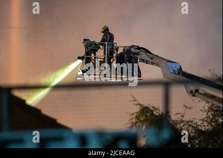 Nechells, Birmingham, England, 12. Juni 2022. Mehr als 100 Feuerwehrleute bekämpfen ein riesiges Inferno auf dem Smurfit Kappa Recycling Compound in Nechells, Birmingham. Die West Midlands Fire Service hat 20 Geräte installiert, darunter zwei hydraulische Hubarbeitsbühnen, mehrere Löschfahrzeuge und eine Hochvolt-Wasserpumpanlage. Bei dem Vorfall werden 8000 Tonnen Papier- und Pappballen in einem Lagerhaus in Brand gesetzt. Quelle: Stop Press Media/Alamy Live News Stockfoto