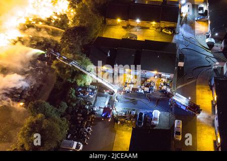 Nechells, Birmingham, England, 12. Juni 2022. Mehr als 100 Feuerwehrleute bekämpfen ein riesiges Inferno auf dem Smurfit Kappa Recycling Compound in Nechells, Birmingham. Die West Midlands Fire Service hat 20 Geräte installiert, darunter zwei hydraulische Hubarbeitsbühnen, mehrere Löschfahrzeuge und eine Hochvolt-Wasserpumpanlage. Bei dem Vorfall werden 8000 Tonnen Papier- und Pappballen in einem Lagerhaus in Brand gesetzt. Quelle: Stop Press Media/Alamy Live News Stockfoto