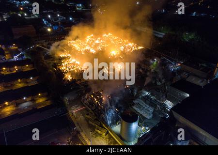 Nechells, Birmingham, England, 12. Juni 2022. Mehr als 100 Feuerwehrleute bekämpfen ein riesiges Inferno auf dem Smurfit Kappa Recycling Compound in Nechells, Birmingham. Die West Midlands Fire Service hat 20 Geräte installiert, darunter zwei hydraulische Hubarbeitsbühnen, mehrere Löschfahrzeuge und eine Hochvolt-Wasserpumpanlage. Bei dem Vorfall werden 8000 Tonnen Papier- und Pappballen in einem Lagerhaus in Brand gesetzt. Quelle: Stop Press Media/Alamy Live News Stockfoto