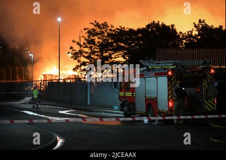 Nechells, Birmingham, England, 12. Juni 2022. Mehr als 100 Feuerwehrleute bekämpfen ein riesiges Inferno auf dem Smurfit Kappa Recycling Compound in Nechells, Birmingham. Die West Midlands Fire Service hat 20 Geräte installiert, darunter zwei hydraulische Hubarbeitsbühnen, mehrere Löschfahrzeuge und eine Hochvolt-Wasserpumpanlage. Bei dem Vorfall werden 8000 Tonnen Papier- und Pappballen in einem Lagerhaus in Brand gesetzt. Quelle: Stop Press Media/Alamy Live News Stockfoto