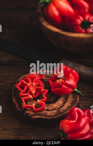 Stillleben von roten Habanero Chili Peppers auf einer dunklen Holzoberfläche Stockfoto