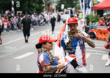 Zwei Teilnehmer der Bushwick Puerto Rico Day Parade mit ihren Haustierschlangen. Stockfoto