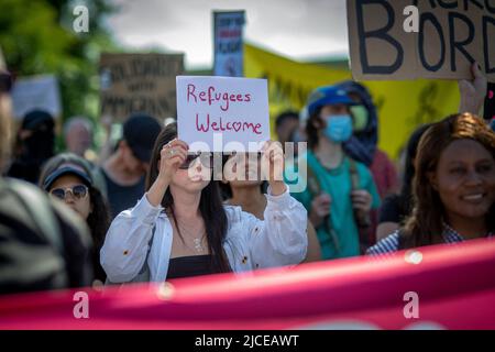 Protestler halten Schild Flüchtlinge in London, England willkommen. Stockfoto