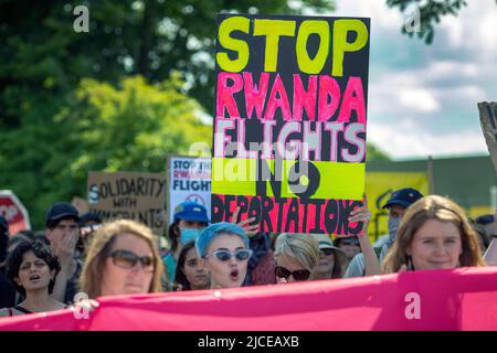 Demonstranten chören und halten Plakate gegen die Abschiebeflüge des Vereinigten Königreichs nach Ruanda in der Nähe des Immigration Removal Center des Brook House am 12. Juni 2022 in London Stockfoto