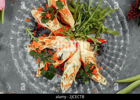 Dünne Pfannkuchen mit Kaviar und Lachs, zu Rollen gerollt Stockfoto