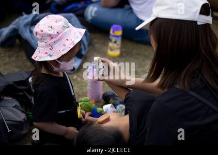 London, Großbritannien. 12.. Juni 2022. Eine Familie wird während der Kundgebung auf dem Parliament Square gesehen. Tausende von Hongkongern in London versammeln sich zum 3.. Jahrestag der prodemokratischen Anti-ELAB-Sozialbewegung in Hongkong zum Gedenken an die Toten, Inhaftierten und Exilanten der Bewegung. Die Kundgebung ist die bisher größte Versammlung von Hongkongers in London seit 2019, als die prodemokratische Bewegung in Hongkong begann. Kredit: SOPA Images Limited/Alamy Live Nachrichten Stockfoto