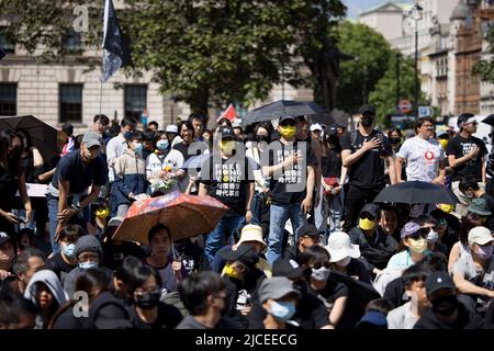 London, Großbritannien. 12.. Juni 2022. Zwei Demonstranten werden in der Menge gesehen, während sie während der Kundgebung auf dem Parliament Square „May Glory Be With Hong Kong“ singen. Tausende von Hongkongern in London versammeln sich zum 3.. Jahrestag der prodemokratischen Anti-ELAB-Sozialbewegung in Hongkong zum Gedenken an die Toten, Inhaftierten und Exilanten der Bewegung. Die Kundgebung ist die bisher größte Versammlung von Hongkongers in London seit 2019, als die prodemokratische Bewegung in Hongkong begann. Kredit: SOPA Images Limited/Alamy Live Nachrichten