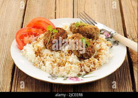 Drei Linsen-Patties mit Reis, Tomaten und Mikrogemüse auf weißem Teller horizontal Stockfoto