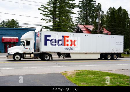 Ein weißer FedEx Sattelzugwagen, der durch Speculator, NY, fährt Stockfoto