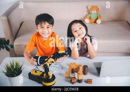 Zwei Kinder programmieren und testen Roboter ARM ihre Wissenschaft, Kid kleines Mädchen Programm Code zu Roboter mit Laptop-Computer und der Junge testen mit Fernbedienung Stockfoto