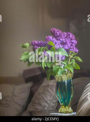 Ein Strauß Flieder in einer Vase auf einem Couchtisch Stockfoto