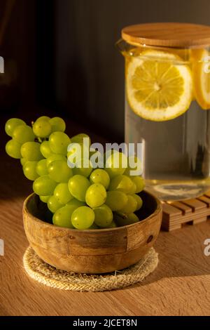 Grüne Trauben liegen auf Öko-Gericht. Umweltfreundliche Wahl und freundliche Natur. Das Konzept der Welt ohne plastikfreien und sauberen Planeten. Umweltfreundliches Geschirr aus natürlichen Materialien Stockfoto