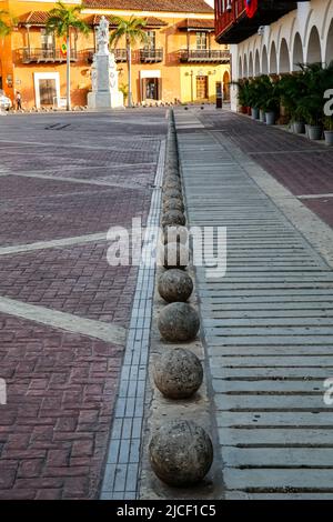 Blick auf einen historischen platz mit aufgereihten Kanonenkugeln, historisches Gebäude im Schatten, Hintergrund mit Häusern im Licht Stockfoto