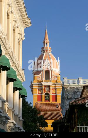 Nahaufnahme des Uhrturms der Kathedrale und der weißen Hausfassade mit blauem Himmel, Cartagena, Kolumbien, UNESCO-Weltkulturerbe Stockfoto