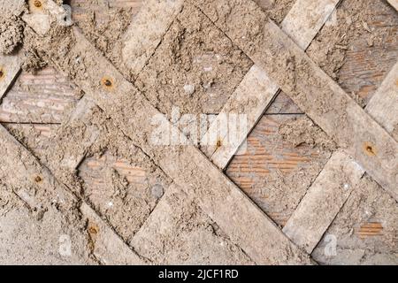 Oberfläche der alten hölzernen Wand mit Ton Gips Mischung mit Brettern bedeckt. Nahaufnahme Stockfoto