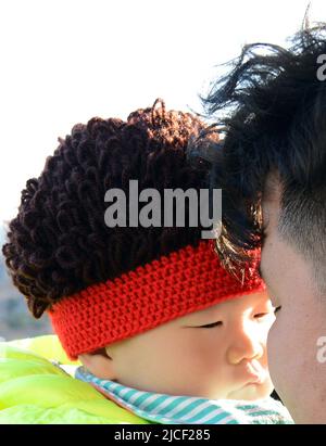 Ein stolzer chinesischer Vater mit seinem niedlichen Baby. Peking, China. Stockfoto