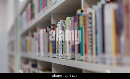 Stuttgart, Deutschland - 16. Nov 2021: Seitenansicht auf einem Bücherregal. Voll mit Büchern. Symbol für Wissen, Lesen und Literatur. Stockfoto