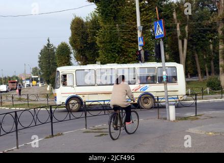 Eine ukrainische Frau, die in Zaschkiv, Ukraine, ihr Fahrrad reitet. Stockfoto