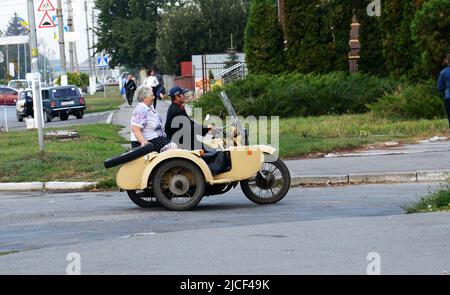 Ein ukrainisches Paar auf einem alten sowjetischen Motorrad mit Seitenwagen in Zaschkiv, Ukraine. Stockfoto