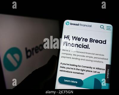 Person, die Mobiltelefon mit der Webseite des US-Unternehmens Bread Financial Holdings Inc. Auf dem Bildschirm vor dem Logo hält. Konzentrieren Sie sich auf die Mitte des Telefondisplays. Stockfoto