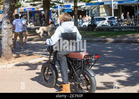 Dieser australische Teenager, der in Manly Beach Sydney ein elektrisches E-Bike von Dirodi Rover fährt, hat fette Reifen und einen großen Sitz für zwei Personen Stockfoto