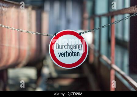 Essen, Deutschland - 26. März 2022: Durchgang verboten (Zutritt verweigert) Schild in einer Fabrik. Rundes Schild, an einer Kette hängend. Verschwommener Hintergrund. Stockfoto