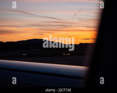 Sonnenuntergang von A320 in Kloten mit Flugzeugflügel im Vordergrund. Stockfoto