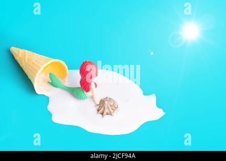 Sonnenbaden Meerjungfrau in Meeresschaum aus geschmolzenem Waffeleisen-Eis auf türkisfarbenem Hintergrund liegend. Stockfoto