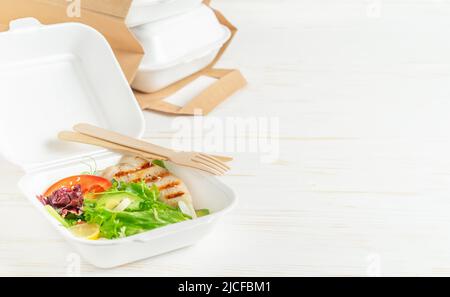 Essenslieferung, Lunchboxen mit Salat auf weißem Holzhintergrund. Speicherplatz kopieren. Stockfoto