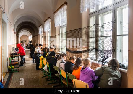 In einer Schule in Chernowitz binden Schüler und Lehrer Tarnnetze ein. Klassen werden abgebrochen. Stockfoto