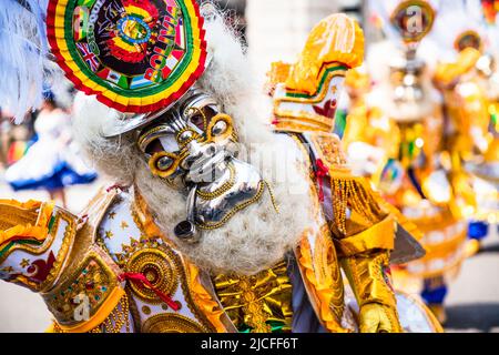 Bunte Maskentänzer in gelbem Kleid feiern während des bolivianischen Festivals der Jungfrau von Urkupiña in den Straßen von Mailand, Italien, Europa Stockfoto