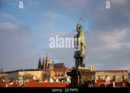 St. Johann von Nepomuk mit Heiligenschein, Bronzestatue auf der Karlsbrücke, Prager Burg dahinter, Hradcany, Prag, Tschechische Republik Stockfoto