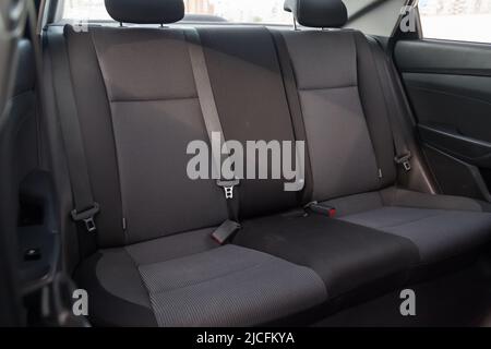 Nahaufnahme der Rücksitze mit Velours-Stoffpolsterung im Innenraum eines alten koreanischen Autos in Grau nach der Trockenreinigung. Kfz-Service-Industrie. Stockfoto