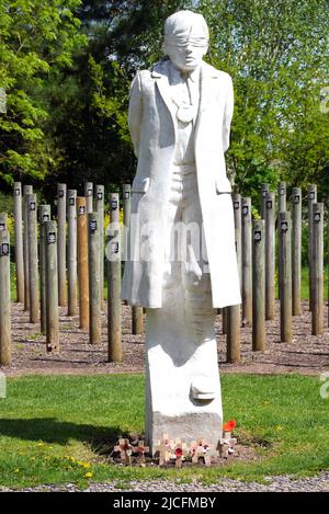 „Shot at Dawn“-Betonfigur eines jungen Soldaten mit verbundenen Augen und Holzpfosten im National Memorial Arboretum, Lichfield, Staffordshire, England Stockfoto