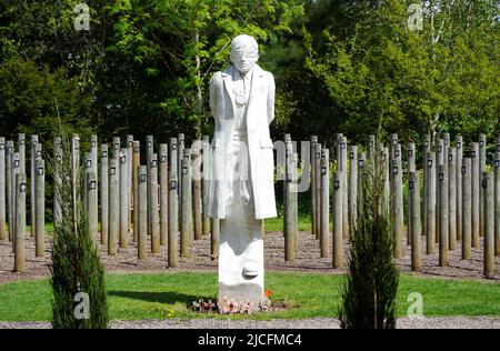 „Shot at Dawn“-Betonfigur eines jungen Soldaten mit verbundenen Augen und Holzpfosten im National Memorial Arboretum, Lichfield, Staffordshire, England Stockfoto