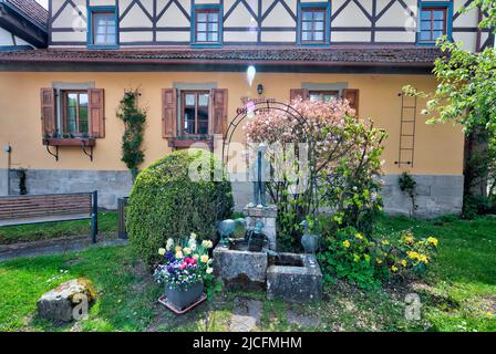 Fachwerk, Frühling im Garten, Brunnen, Hausfassade, Frühling, Unfinden, Königsberg, Franken, Bayern, Deutschland, Europa, Stockfoto