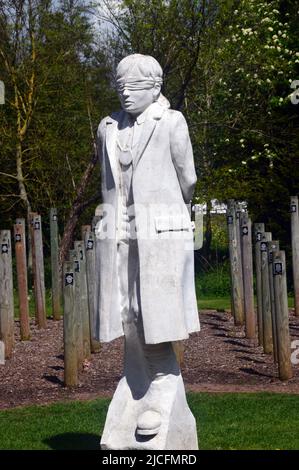 „Shot at Dawn“-Betonfigur eines jungen Soldaten mit verbundenen Augen und Holzpfosten im National Memorial Arboretum, Lichfield, Staffordshire, England Stockfoto