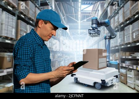 Warehouse Manager mit digitalem Tablet steuert Roboter Stockfoto