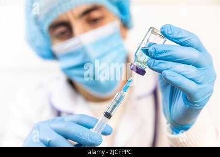 Arzt Füll Spritze mit Medikamenten, Nahaufnahme. Impfungen und Impfungen. Selektiver Fokus. Stockfoto