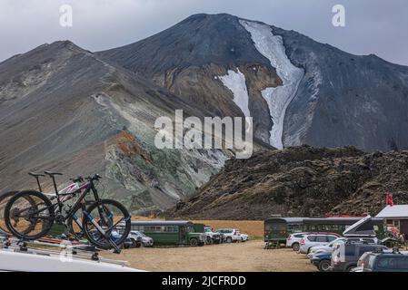 Der Laugavegur-Wanderweg ist die berühmteste mehrtägige Trekkingtour in Island. Landschaft aufgenommen aus dem Gebiet um Landmannalaugar, Ausgangspunkt des Fernwanderweges im Hochland Islands. Mountainbikes auf einem Autodach auf dem Parkplatz. Stockfoto