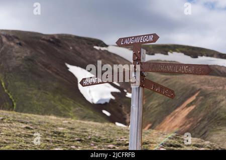 Der Laugavegur-Wanderweg ist die berühmteste mehrtägige Trekkingtour in Island. Landschaft aufgenommen aus dem Gebiet um Landmannalaugar, Ausgangspunkt des Fernwanderweges im Hochland Islands. Rostiger Wegweiser 'Hrafntinnusker'. Stockfoto