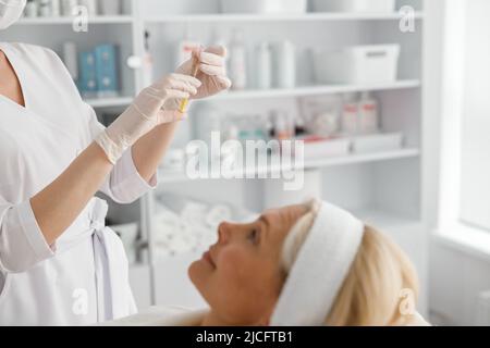 Ein professioneller Arzt bereitet eine Spritze für die Injektion im Schönheitssalon vor Stockfoto