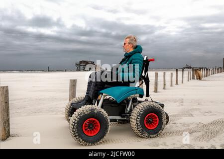 Mann im Strandrollstuhl, Strandurlaub genießen, Sankt-Peter-Ording, Schleswig-Holstein, Deutschland Stockfoto